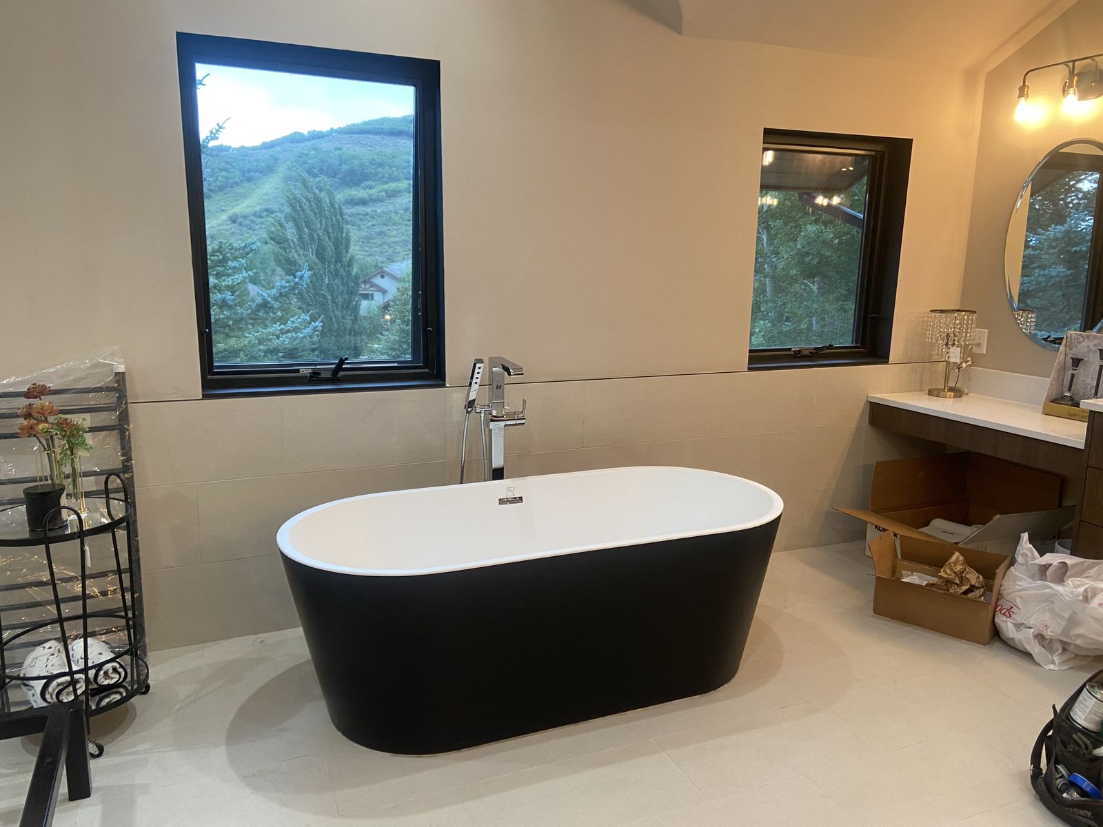 Freestanding soaking tub beneath a mountain view window